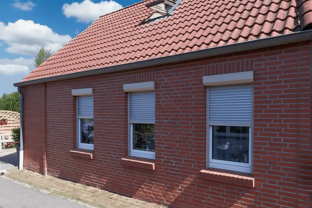 Rollläden an den Fenstern eines roten Backsteinhauses